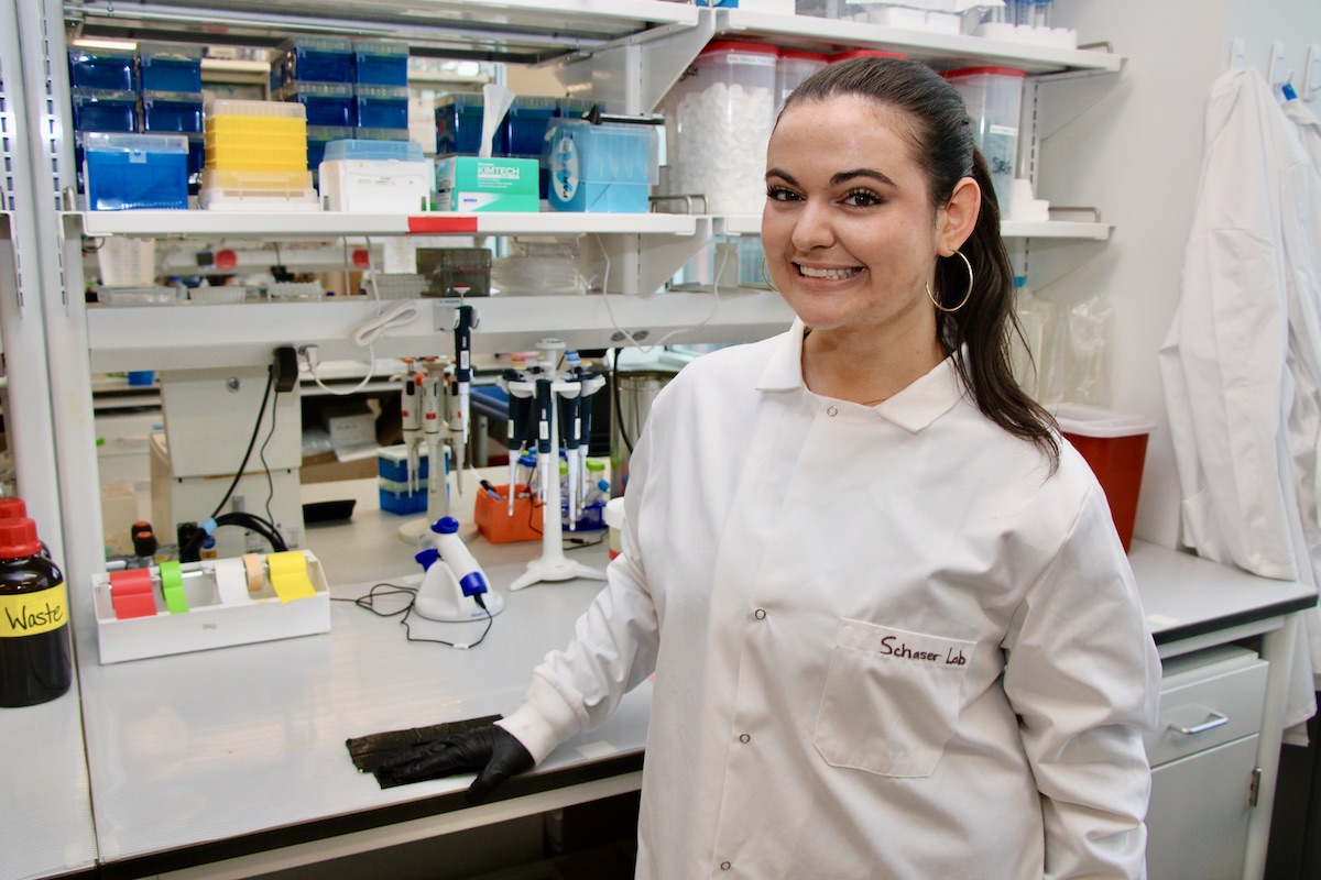 Bella Ross stands in a lab wearing a lab coat.