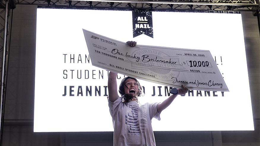 Purdue student Isabella Bartol holds up an oversized check for $10,000 at the Purdue Day of Giving After Dark student event